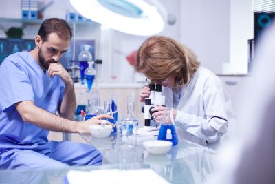 Female scientist looking through a microscope in laboratory