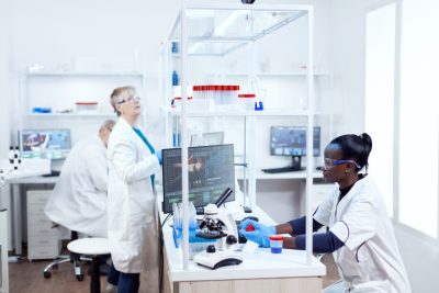 Scientist with african ethnicity holding sample recipient